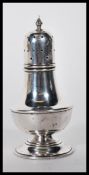 A early 20th Century silver hallmarked sugar shaker/ caster having shaped body with pierced design