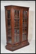 A 20th century French style hardwood display cabinet being raised on plinth base having two
