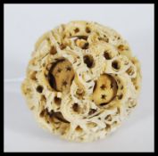 An early 20th Century carved ivory Chinese puzzle ball having six concentric balls, being carved
