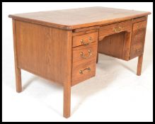 A mid century retro oak Air Ministry desk being raised on squared legs with pedestals of drawers