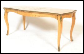 A 20th Century quarter panel Burr Walnut veneered coffee table of rectangular form, raised on French