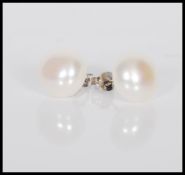 A pair of cultured pearl stud earrings on silver posts, stamped 925.