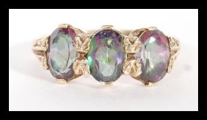 A 9ct gold hallmarked Mystic Topaz having 3 faced cut oval topaz stones in a gypsy style setting.