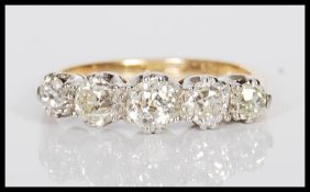 A stamped 18ct gold and platinum ladies dress ring prong set with five round cut diamonds. Estimated