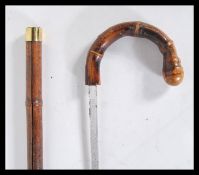 A 20th Century walking sword stick having crook handle with carved knob and brass band. handle pulls