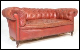 A late Victorian deep-buttoned back Chesterfield sofa with red leather upholstery, horsehair