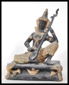 A 20th Century cast bronze figurine of a Thai Zen buddha depicted seated playing a lute having