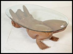 A retro 20th Century Burmese carved hardwood glass topped coffee table, the carved table base