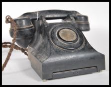 A vintage 20th Century bakelite telephone on a square base, having a pull out phone number tray