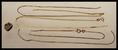 A collection of 9ct gold jewellery to include three fine necklace chains along with a heart shaped