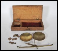 A set of vintage postage scales set within a wooden case along with a selection of brass weights