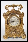 An early 20th Century gilt cast carriage clock, the clock cast in relief in the rococo taste