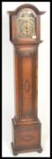 An early 20th century grandmother clock having oak case and windup movement with brass face