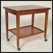 A vintage retro mid 20th Century teak wood tea trolly / card table having a two tiers with a