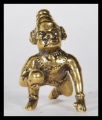 A 19th Century cast Indian gilt bronze figurine of Balakrishna in the crawling pose hold a butter