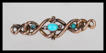 A 19th Century Victorian knot brooch having a central oval turquoise cabochon flanked by two half