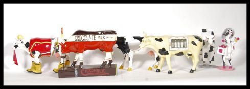A collection novelty cow figurines by Cow Parade Holdings to include 'Udder Cowstruction', extra