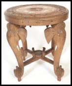 An early 20th century African hardwood occasional table being raised on feet in the form of