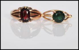 Two 9ct gold ladies dress rings to include a split band ring set with an oval cut red stone (