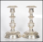A pair of early 20th Century style silver plate candlesticks having engraved geometric decoration