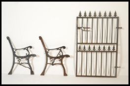 A pair of early 20th Century cast iron bench end finished in black. Together with a decorative