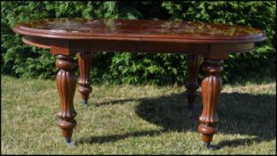 An impressive large Victorian style mahogany triple leaf extending dining table. Raised on