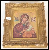 A 20th Century icon of Mary and the Infant Jesus set within a 19th Century ornate gesso gilt