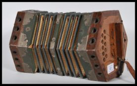 A vintage early 20th Century squeeze box of hexagonal form having pierced wood handles at each end