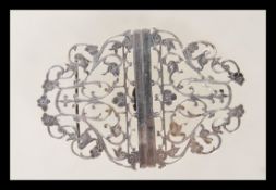 A silver hallmarked nurses belt buckle having pierced fret work decoration with scrolled floral