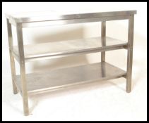 A 20th Century stainless steel industrial kitchen work table, flared worktop  raised on square