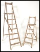 Two vintage 20th Century wooden Industrial framed step ladders, both different size being of a-frame