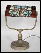 A good 20th century brass bankers desk lamp raised on a round base with a leaded and stained glass