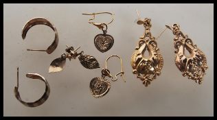 A selection of 9ct gold earrings to include a pair of three tone hoop earrings, a pair of heart