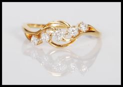 A stamped 18k / 18ct gold ring set with five brilliant cut diamonds. Estimated diamond total
