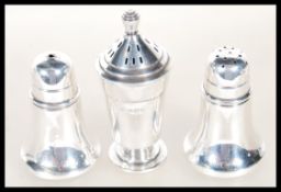 A pair of silver hallmarked salt and pepper pots having hallmarks for Birmingham dated 1932 by A.