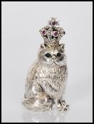 A sterling silver figure of cat having green emerald eyes, wearing a crown set with rubies.