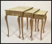 A Louis XVi style gilded nest of three graduating tables of three, shaped supports with faux