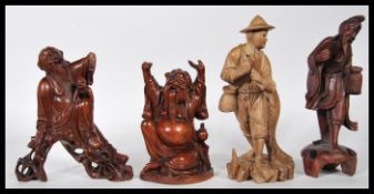 A group of four 20th Century carved hardwood figures, one being Iron Crutch Li, a fisherman carrying