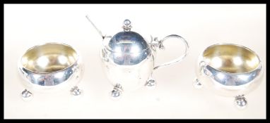 A 3 piece hallmarked silver cruet set havig 2 salts pots and a mustard pot on ball feet  with a