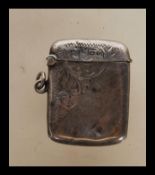 A mid 20th Century silver hallmarked vesta case having engraved scrolled decoration, hinged lid