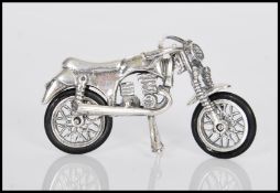 A novelty silver motorcycle being articulated, having rubber tyres with bike stand down. Weighs 13.