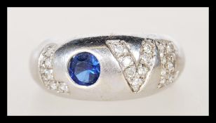 A hallmarked 9ct white gold ring having white accent stones spelling 'Love' with a central blue