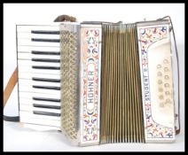 A 20th Century Hohner Student ll (2) piano accordion, having its original leather strap and original