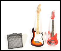 A six string electric child's guitar by Rayon having a red body together with a six string three-