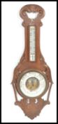 An early 20th Century 1920's oak cased Aneroid barometer having carved scroll work. Set with a white
