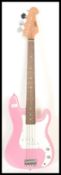 A four string electric bass guitar by swift having a hot pink sprayed body with white scratch guard.