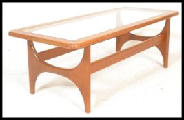 A vintage retro 20th century teak wood coffee table raised on shaped  supports united by