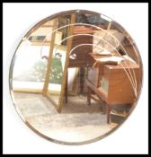 A vintage mid 20th Century 1950's wall mirror of round form with bevelled glass having a floral