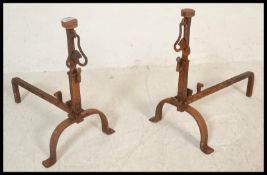 A pair of 19th Century French hand forged wrought iron fire dogs / chennets, raised on scrolled