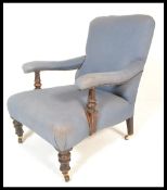 A Victorian 19th century mahogany library armchair being raised on mahogany legs terminating in